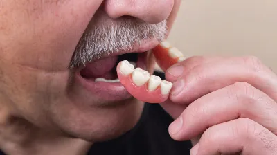 Man putting on dentures