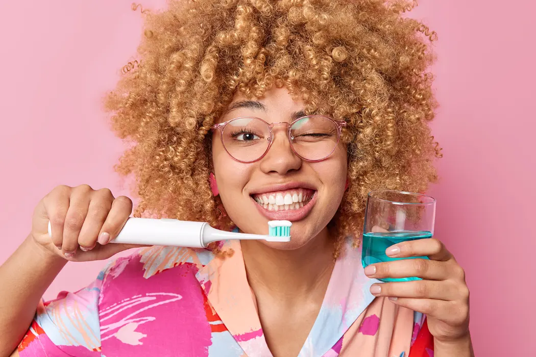 Woman smiling brishing her teeth