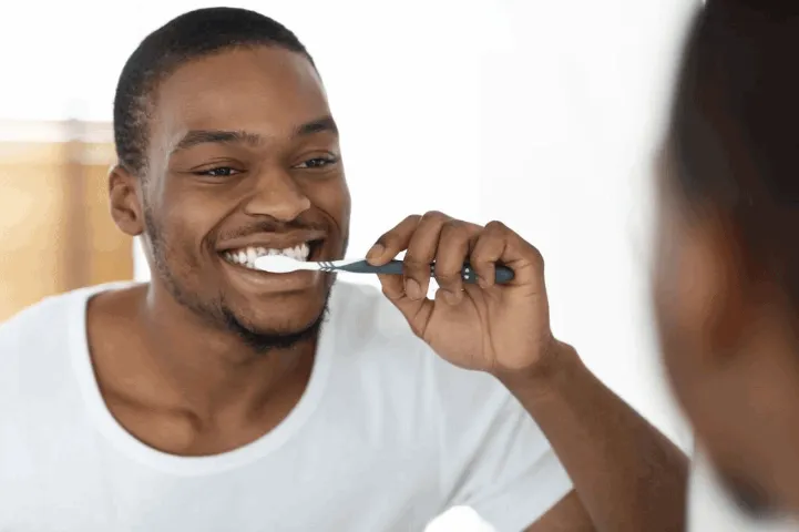 black man brushing his teeth