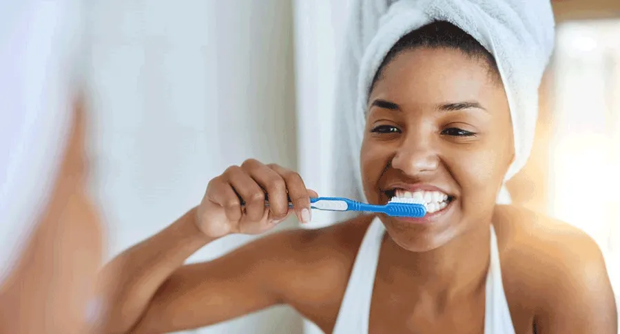 black woman brushing her teeth