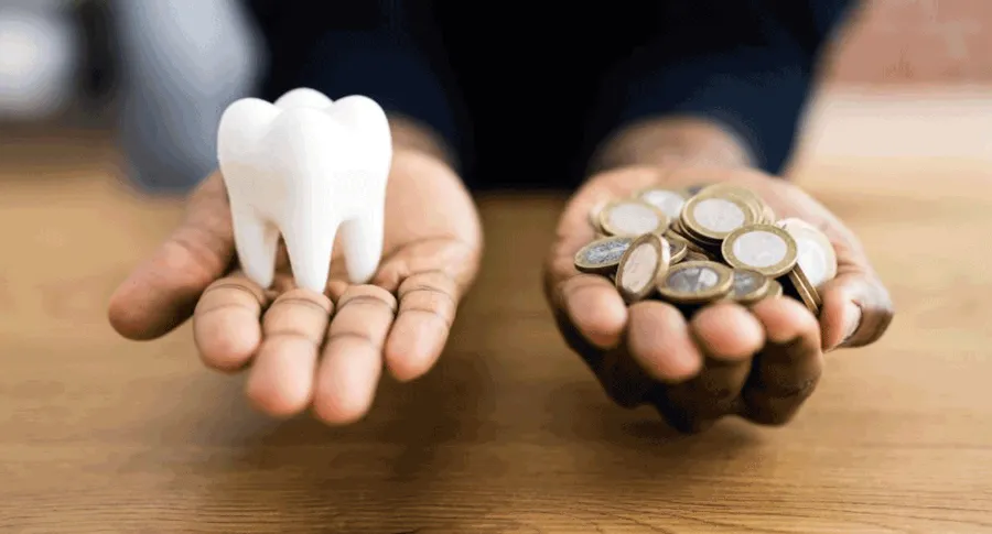 coins and tooth on hand