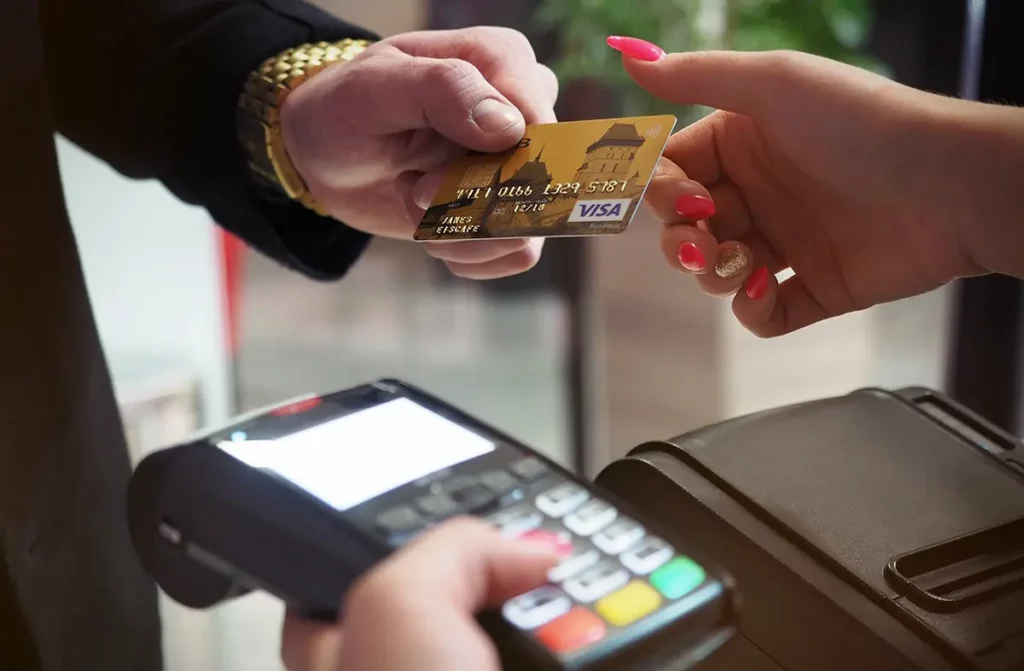 Man handing credit card to woman