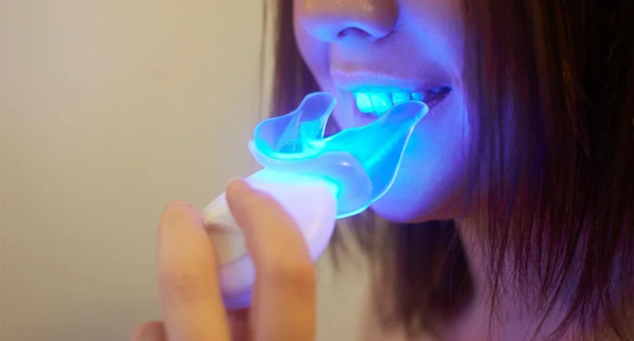 Woman doing teeth whitening at home