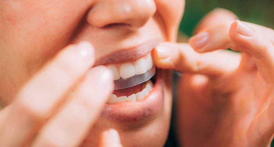 Woman applying teeth whitening strips