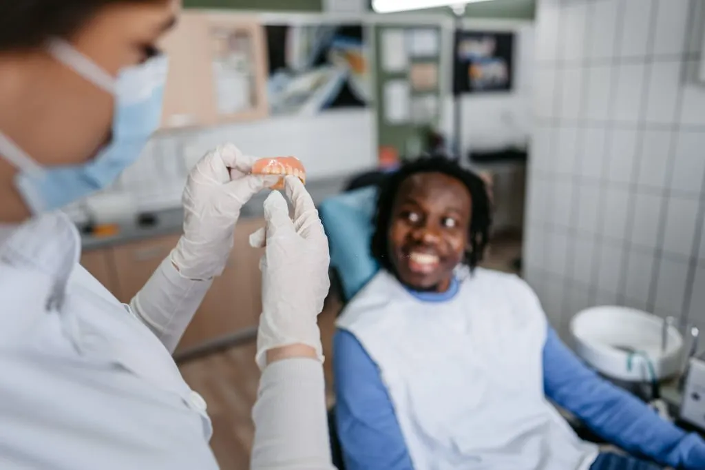 Doctor showing a patient dentures