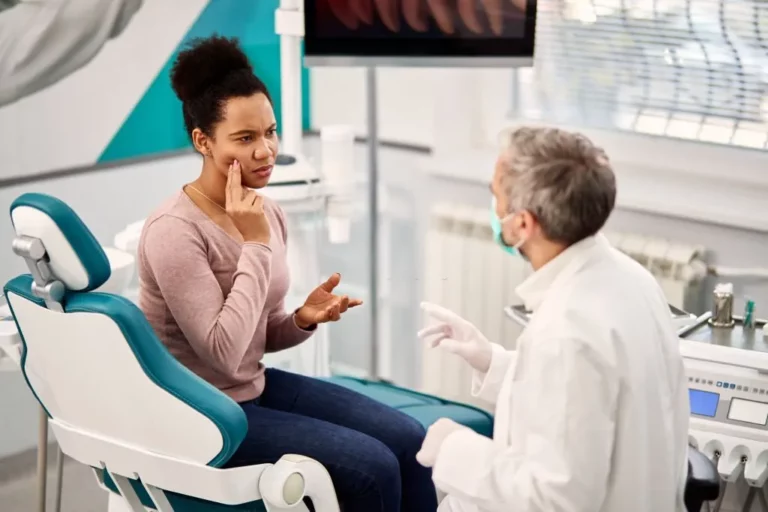 Woman showing an impression of the toothache talking to the dentist