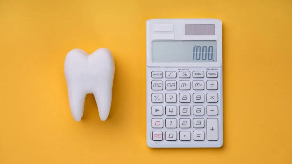 Tooth and a calculator on a yellow surface