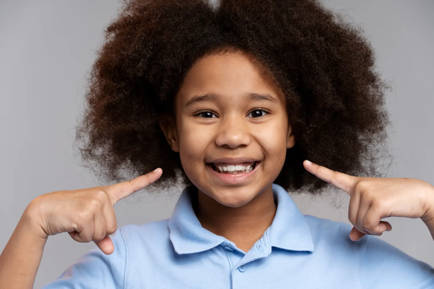 Black child pointing at teeth