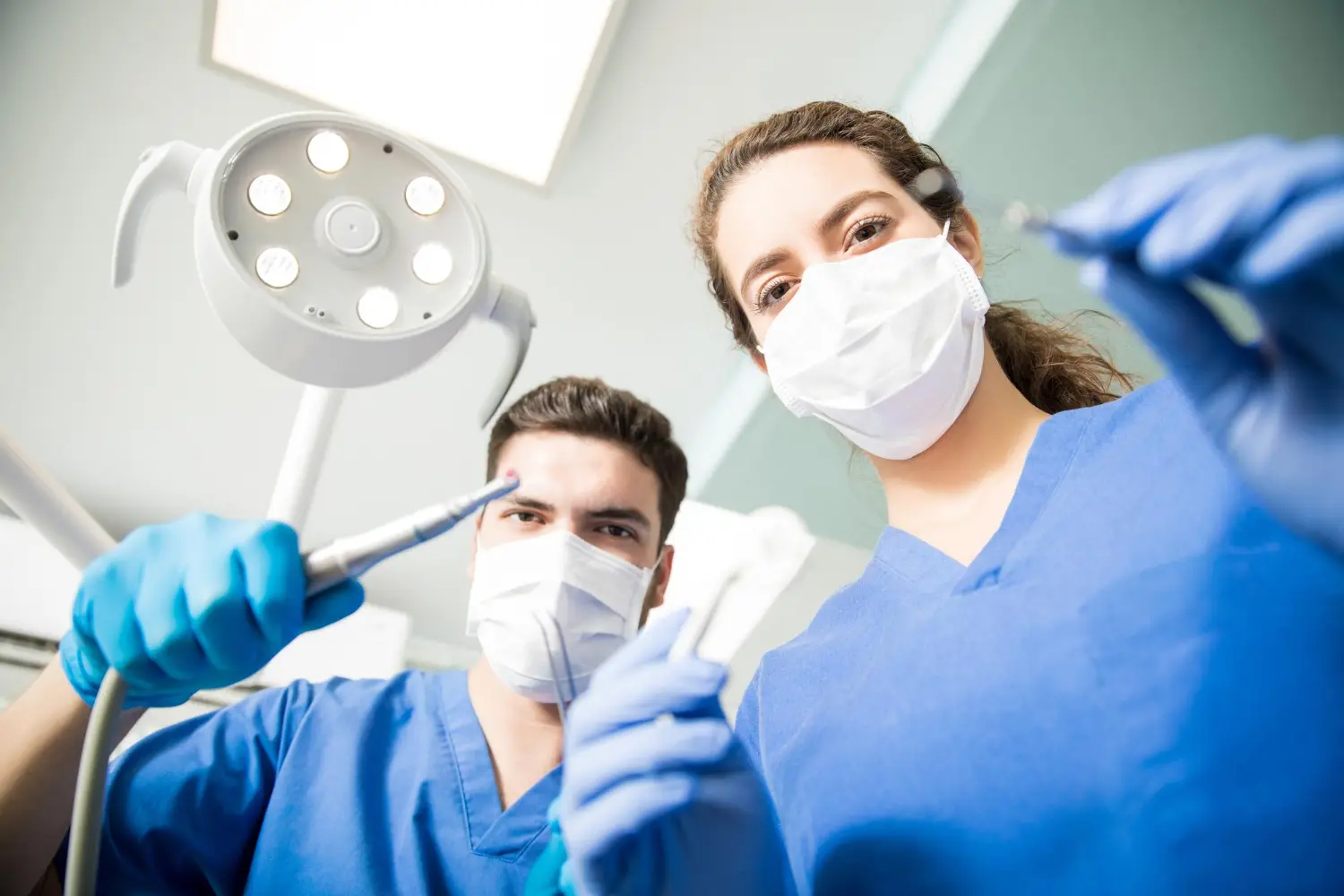 Two white Dentists holding dental equiptments