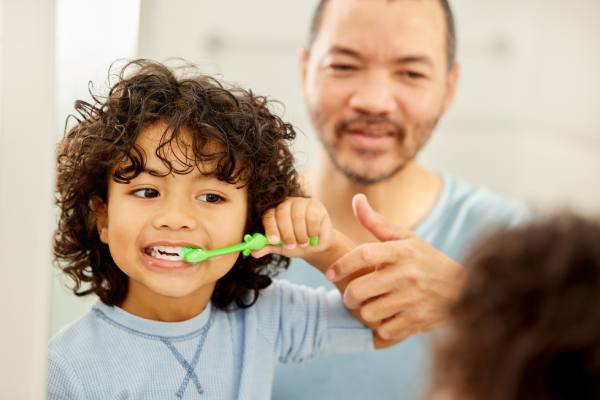 father child teeth brushing